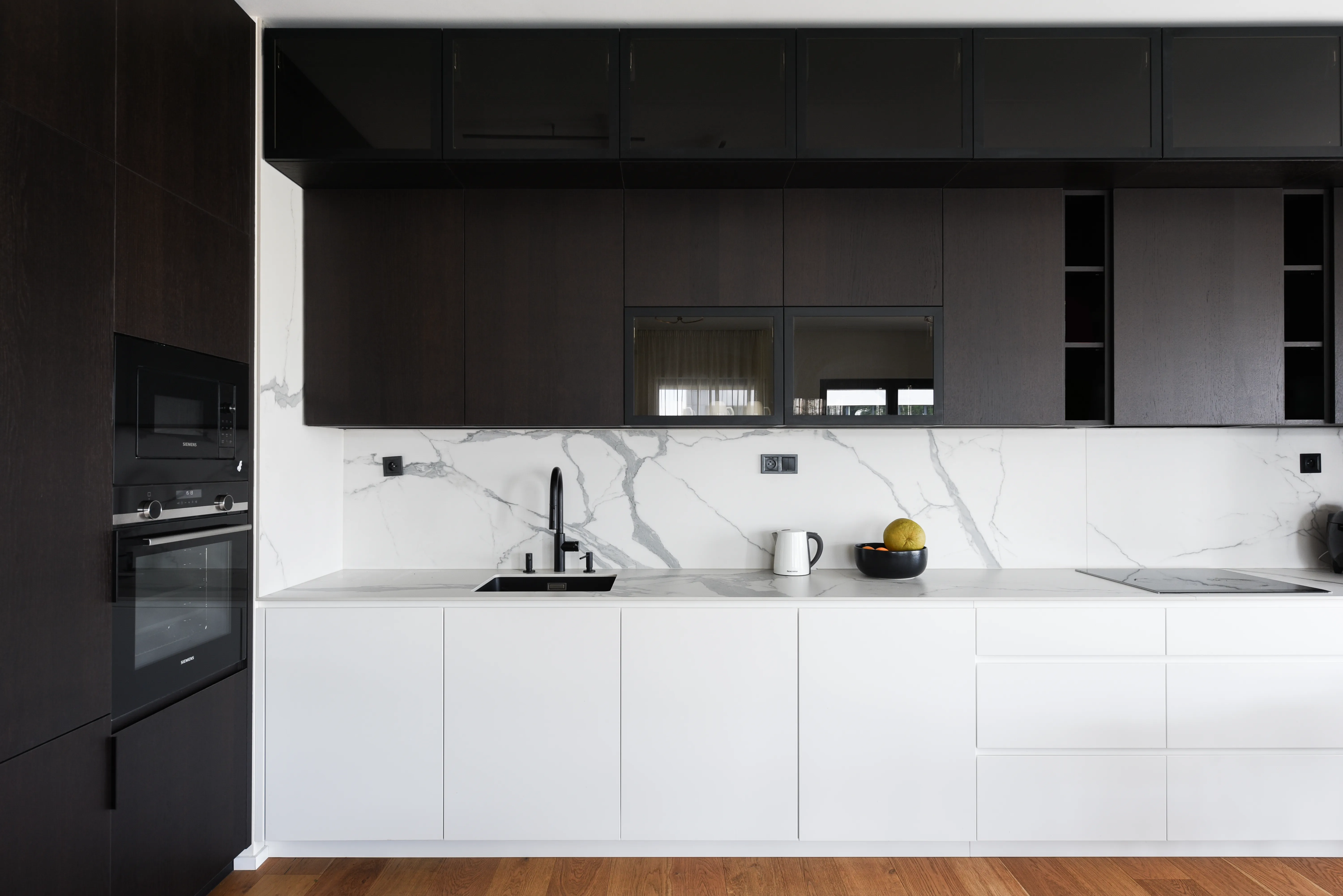 Kitchen unit in combination of lacquered white mat with dark walnut veneer and Technistone worktop